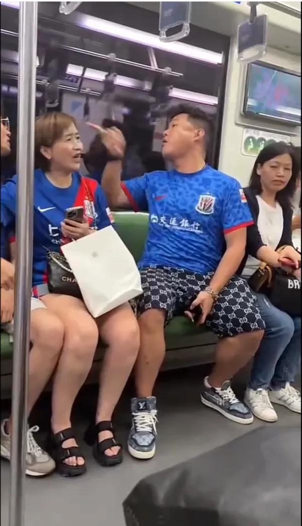两个上海男球迷在地铁上吵架，吵得很激烈，你一句我一句架势看上去火药味很浓，手都指
